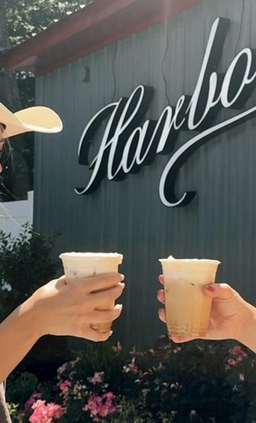 Iced coffees raised under the Harbor sign in Goshen